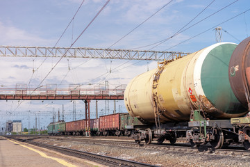 Fototapeta na wymiar View of railway station with industrial freight trains on railroad under summer sky with clouds. Russia, May 2018
