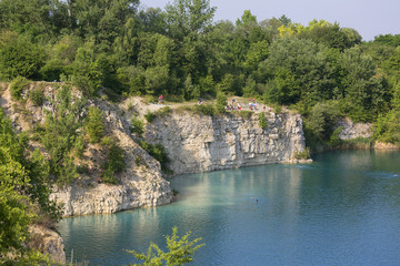 Fototapeta na wymiar Lagoon Zakrzowek in an old limestone quarry, emerald water, resting people, Krakow, Poland
