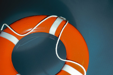 An orange life saver in a dark pool