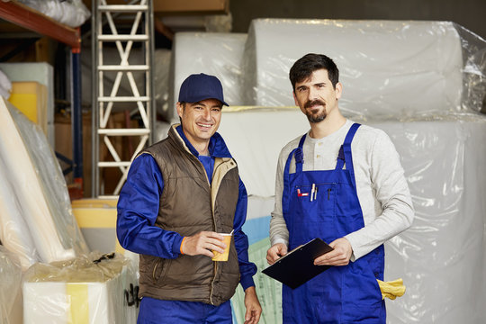 Confident Male Workers Standing At Sofa Workshop