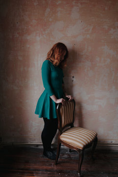 potrait of a woman standing behind a chair