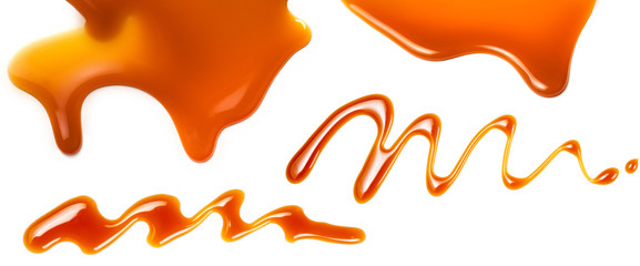 Caramel splashes isolated on white background. Spilled caramel sauce, toffee  liquid toppings....