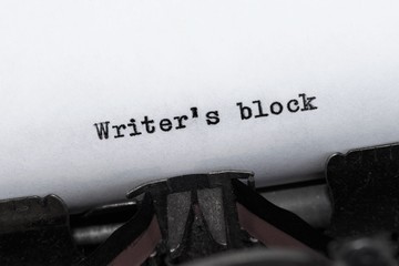 Writer's block typed by a vintage typewriter onto white paper. The message is on an angle. 