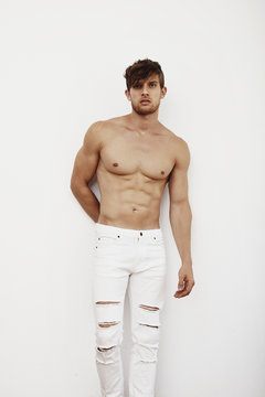 Strong handsome model posing against white background