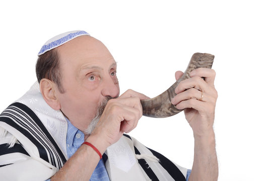 Eldery jewish man blowing the Shofar horn for Rosh Hashanah