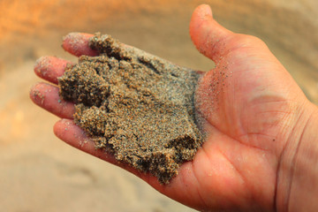 Small particles of sand dries on the warm palm between the tender fingertips.