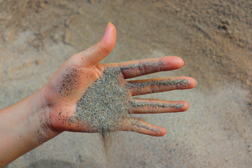 Small particles of sand dries on the warm palm between the tender fingertips.