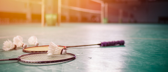 Badminton ball (shuttlecock) and racket on court floor - obrazy, fototapety, plakaty