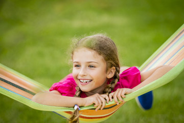 Young girl relaxing on the hammock in garden.