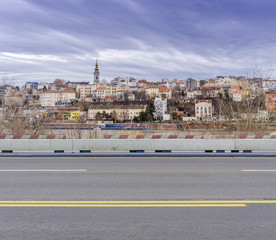 Empty asphalt city bridge road with city and river in the background