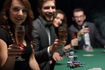 fashion woman with glasses of wine,sitting at a table in a casino