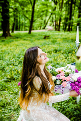 Naklejka premium Beautiful girl in white dress sitting at a table with flowers