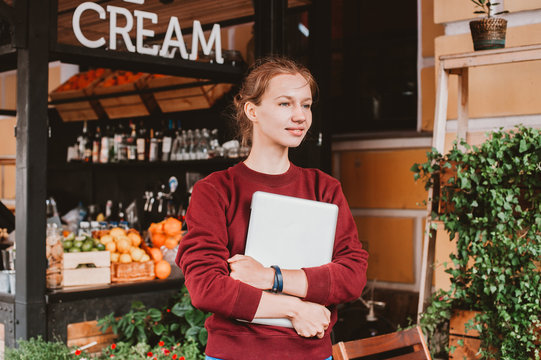 Young Woman Holding Laptop And Smiling