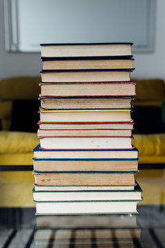 Stack of old books on a glass coffee table