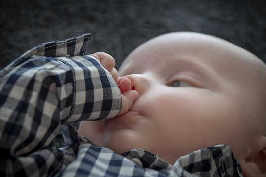 Four Month Old Baby Boy With Blue Eyes, Wearing A Blue Check Shirt