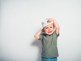 Cute little boy with hat posing on white