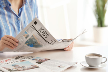 Woman reading morning newspaper indoors