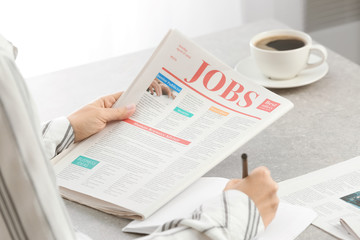 Woman reading morning newspaper indoors