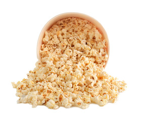 Overturned cup with tasty popcorn on white background