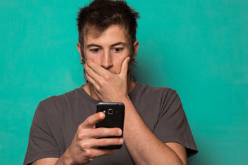 Guy making a selfie with funny faces. Guy taking pictures with his smartphone