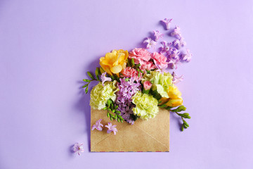 Open mail envelope with flowers on color background