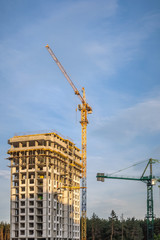 Construction cranes at sunset