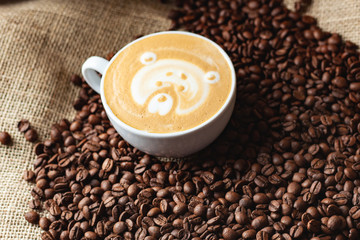 Cappuccino with a pattern on the background of coffee beans