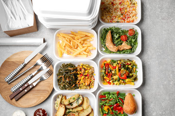 Foam plastic containers with delicious food on table