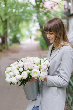 Beautiful bouquet of white peonies in woomans hands . Floral composition, daylight. Wallpaper. Vertical photo