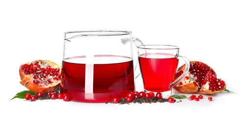 Red tea in glass cup and pot with pomegranate on white background