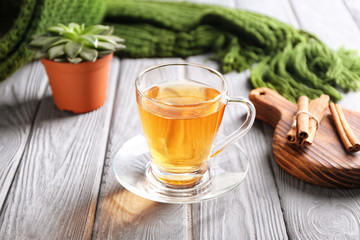 Glass cup with delicious tea on wooden table