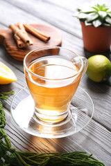 Glass cup with delicious tea on wooden table