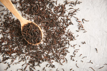 Dry tea and wooden spoon on grey background, top view