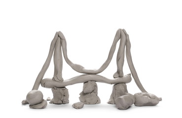 Grey modelling clay lumps, bridge shape isolated on white background