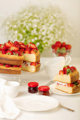 Homemade strawberry cake on a glass stand on the white background.