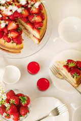 Homemade strawberry cake on a glass stand on the white background.