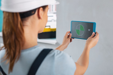 Building. Young professional builder wearing a uniform and working with her instruments