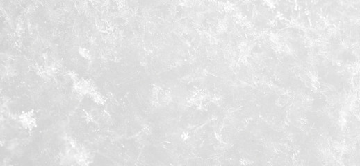 Snowflakes lie on white snow. Brilliant background.