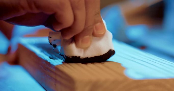 Stunning 4K, macro footage of wood being treated with a stain.