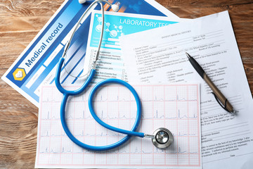 Composition with stethoscope and documents on wooden background. Health care concept