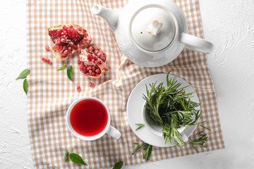 Composition with cup of hot aromatic tea on table