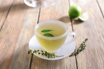 Obraz na płótnie Canvas Glass cup of hot aromatic tea on wooden table