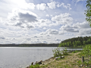 Summer landscape: blue lake on a Sunny day and sky with feathery clouds