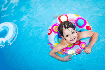 Little girl in swimming pool with float ring