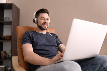 Freelancer with headphones using laptop at home