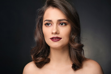 Portrait of young woman with beautiful makeup on black background. Professional cosmetics