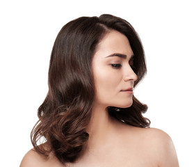 Naklejka premium Beautiful young woman with healthy dark wavy hair and natural makeup, skincare and beauty portrait isolated