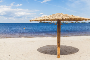 Sunshade on sandy beach on summer day
