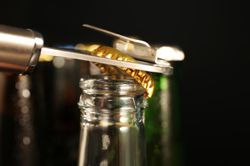 Opening of glass bottle with cold beer, closeup