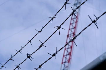 Barbed wire and sky backdrop.